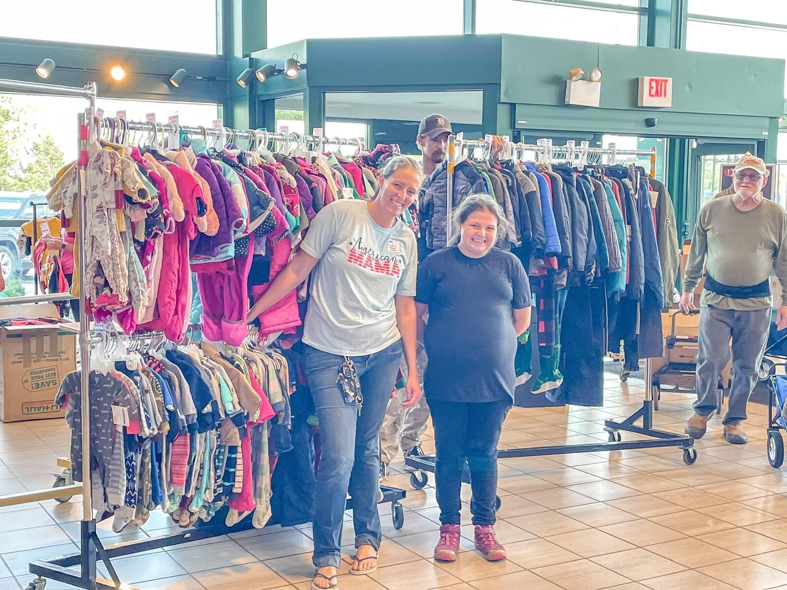 Mom and grandmother stand together, a few pieces of clothing in grandmom's hands, as they shop together for their family.